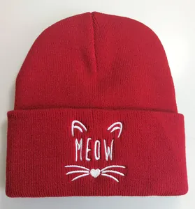 Detailaufnahme der roten Rippstrickmütze mit weißer Meow-Stickerei und Katzenmotiven