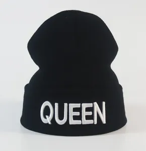Detail der weißen QUEEN Stickerei auf einer schwarzen gerippten Strickmütze
