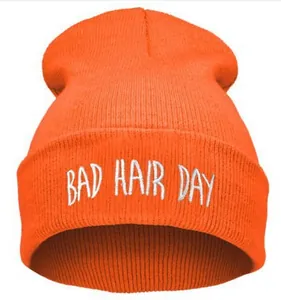 Détail de la broderie blanche BAD HAIR DAY sur le bonnet en maille côtelée orange