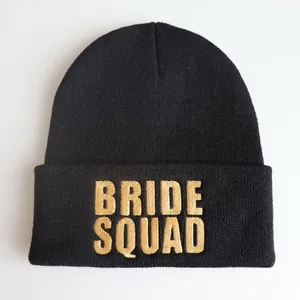 Detail der goldenen BRIDE SQUAD Bestickung auf einer schwarzen Strickmütze