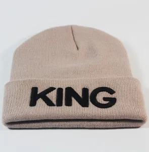 Detailaufnahme der King-Stickerei auf einer warmen khaki-gerippten Strickmütze für Winter