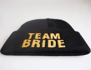 Detail der goldenen Team Bride Stickerei auf einer schwarzen Strickmütze