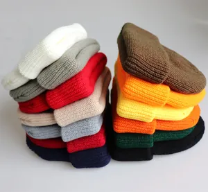 Stapel gerippter Strickmützen in vielen Farben mit Fokus auf Textur und dicken Stoff