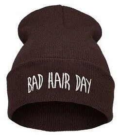 Détail de la broderie blanche Bad Hair Day sur le revers d'un bonnet en tricot marron