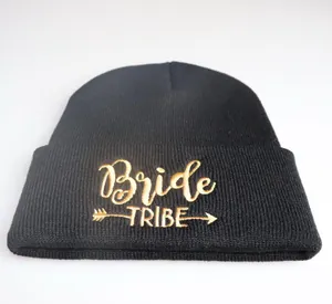 Detailaufnahme der goldenen Bride TRIBE Stickerei auf schwarzer Strickmütze