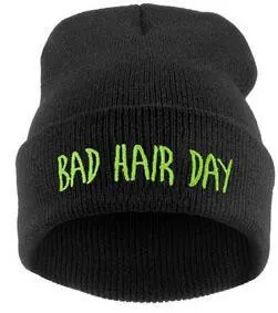 Détail de la broderie Bad Hair Day sur un bonnet en tricot noir avec lettres vertes
