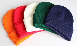 Detailaufnahme von gerippten Strickmützen in fünf Farben mit klassischem Umschlag