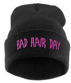 Détail de la broderie rose BAD HAIR DAY sur un bonnet en maille noire à revers