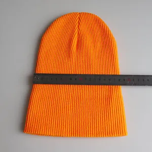 Detailansicht der orangefarbenen Strickmütze mit Maßband zeigt die Breite von 20cm