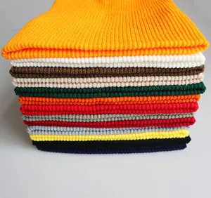 Detailaufnahme verschiedenfarbiger Strickmützen mit hochwertiger Rippenstruktur im Stapel