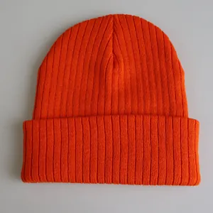 Detailansicht der leuchtend orangefarbenen Rippstrickstruktur einer langen Wintermütze