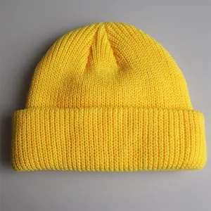 Detail der gelben Strickmütze mit feiner Rippstruktur und umgeschlagenem Randdesign