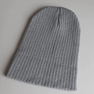 Detailaufnahme der gerippten Textur einer langen grauen Strickmütze für den Winter