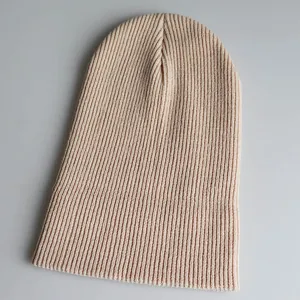 Detailansicht der Rippstrick-Textur und des weichen aprikosenfarbenen Garns der Beanie