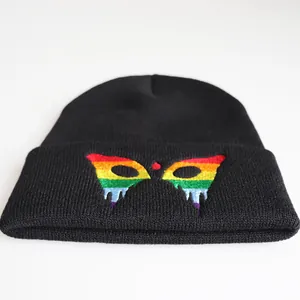 Macro detail of the rainbow flag embroidery on a thick black knitted beanie hat
