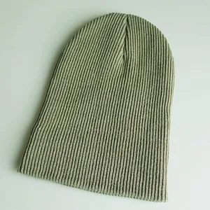 Makro-Detail der salbeigrünen Rippstrick-Struktur dieser langen, warmen Winter-Beanie-Mütze