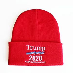 Detail der Trump 2020 Bestickung und USA-Flagge auf roter gestrickter Umschlagmütze