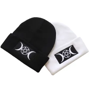 Detail of GOTH beanie embroidery featuring triple moon goddess and pentagram on knit fabric