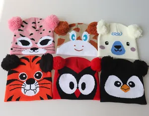 Flat lay of six diverse animal-themed children's knit hats with dual plush pom-poms
