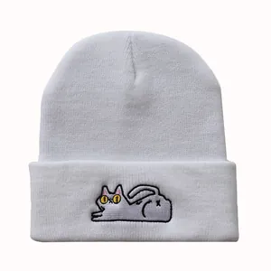 Nahaufnahme der süßen Katzenstickerei auf einer weißen Strickmütze mit hochwertiger Textur