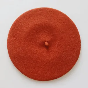 Vue détaillée du dessus d'un béret en laine orange citrouille avec petit détail
