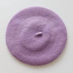 Vue de dessus d'un béret en laine violette montrant une texture douce et haut de gamme