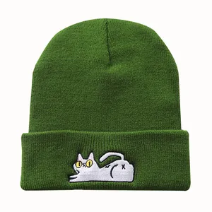 Detailansicht der dunkelgrünen Strickmütze mit weißer Katzenstickerei auf dem Umschlag