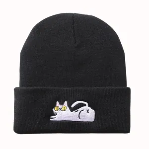 Detailansicht der niedlichen weißen Katzenstickerei auf schwarzer Strickmütze für Damen