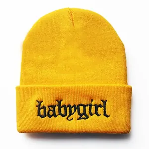 Detail der gelben Strickmütze mit gotischer Babygirl-Stickerei auf dem Umschlag