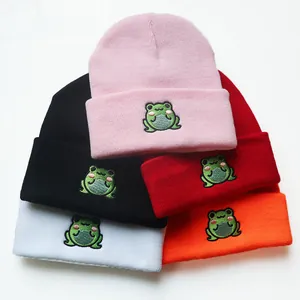 Stapel bunter Strickmützen mit süßer grüner Froschstickerei in verschiedenen kräftigen Farben