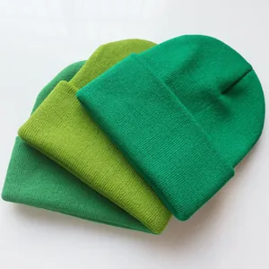Drei Grüntöne gerippte Strickmützen in schlichten Unifarben auf weißem Hintergrund