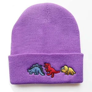 Detailansicht der lila Strickmütze mit Bestickung von drei bunten Comic-Dinosauriern