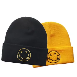 Black and yellow knit beanies with embroidered 90s grunge smiley face for winter warmth