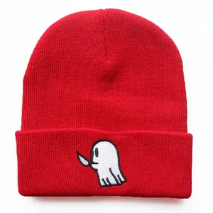 Detailansicht der Cartoon-Geist-Stickerei mit Messer auf roter Strickmütze Beanie