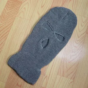 Detalle del tejido de un pasamontañas gris de 3 agujeros para protección de invierno