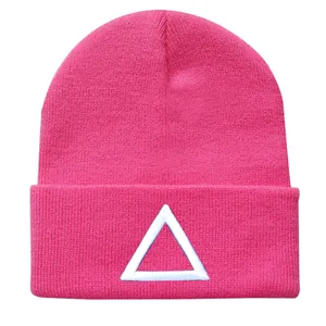 Detailaufnahme einer pinkfarbenen Strickmütze mit weißem gesticktem Dreiecks-Logo