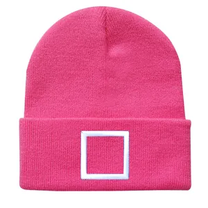 Detailansicht der rosa Strickmütze mit weißer Quadrat-Stickerei auf dem Umschlag