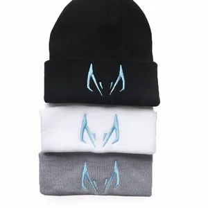 Schwarze weiße und graue Strickmützen mit blauer Stickerei für winterliche Wärme