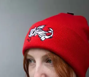 Detailed embroidery of a dragon on a red ribbed knit beanie for winter outdoor sports