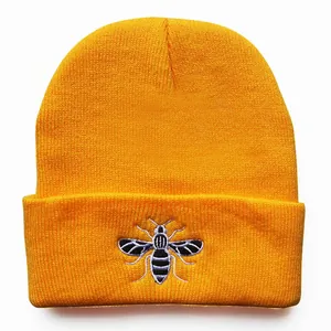 Yellow ribbed knit beanie with bee embroidery on the cuff for winter warmth