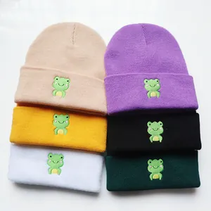 Nahaufnahme von Strickmützen in sechs Farben mit Cartoon-Frosch-Stickerei