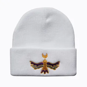 Close-up of white knit beanie featuring detailed colorful Moon Bird embroidery detail