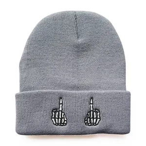 Detail der grauen Strickmütze mit weißen Totenkopf-Handstickereien am umgeschlagenen Rand