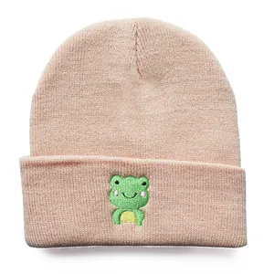 Rosa Strickmütze mit niedlicher grüner Cartoon-Frosch-Stickerei im minimalistischen Stil