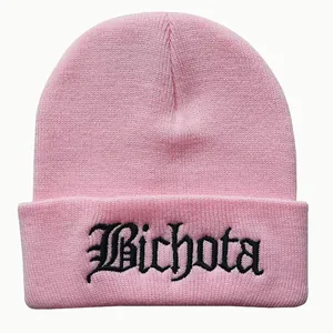 Detailed close-up of pink knit beanie with black Bichota gothic embroidery