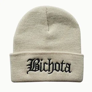 Close-up of black Bichota embroidery on a beige cuffed knit beanie for winter