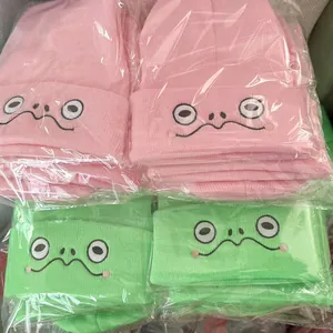 Set aus rosa und grünen Strickmützen mit lustigem Stickgesicht in Einzelverpackung