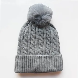 Soft grey cable knit beanie with pom-pom and fleece lining for winter warmth
