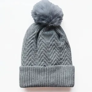 Graue Strickmütze für den Winter mit großem Kunstfell-Bommel und Rippstrickbündchen