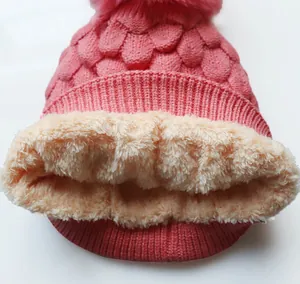 Detail der rosa Strickmütze mit weichem beigem Fleecefutter und Bommel-Akzent